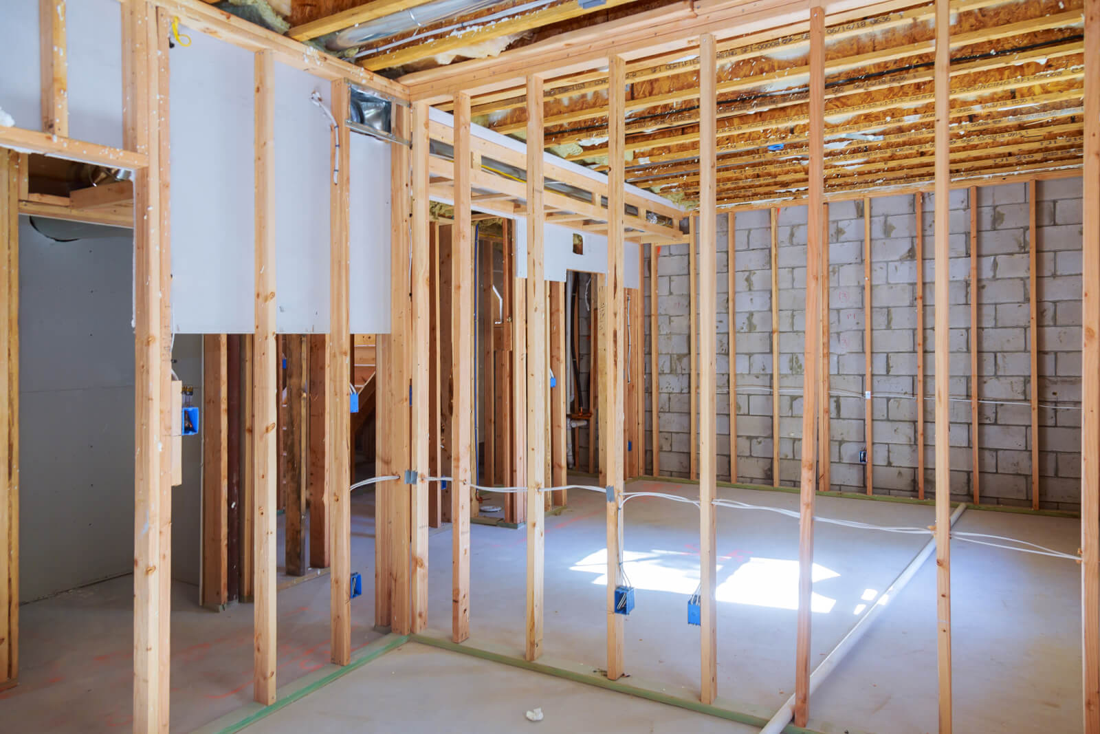 A basement remodel in progress, framing and subfloor visible