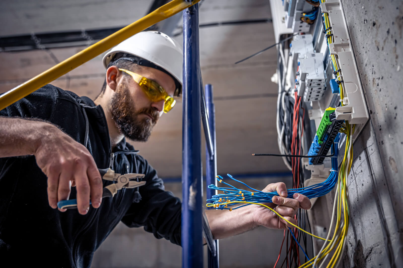 An electrician wiring a residential breaker panel