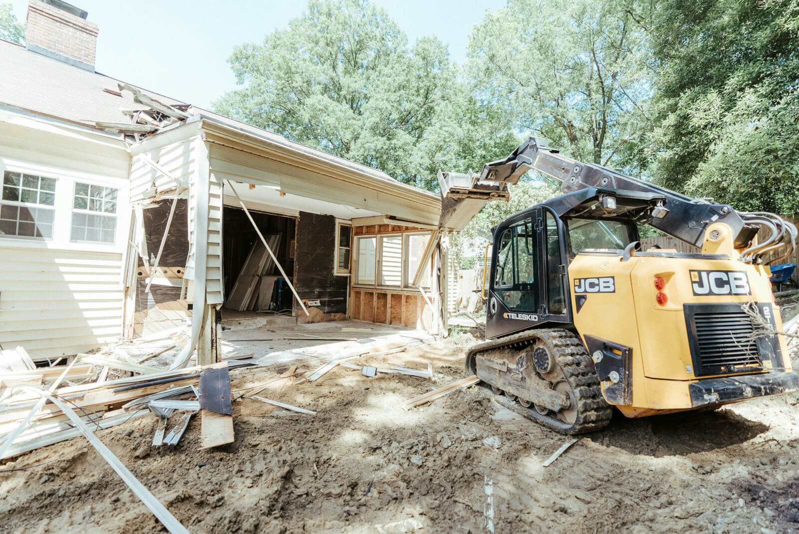 A crew installing steel piers along the foundation of a brick home