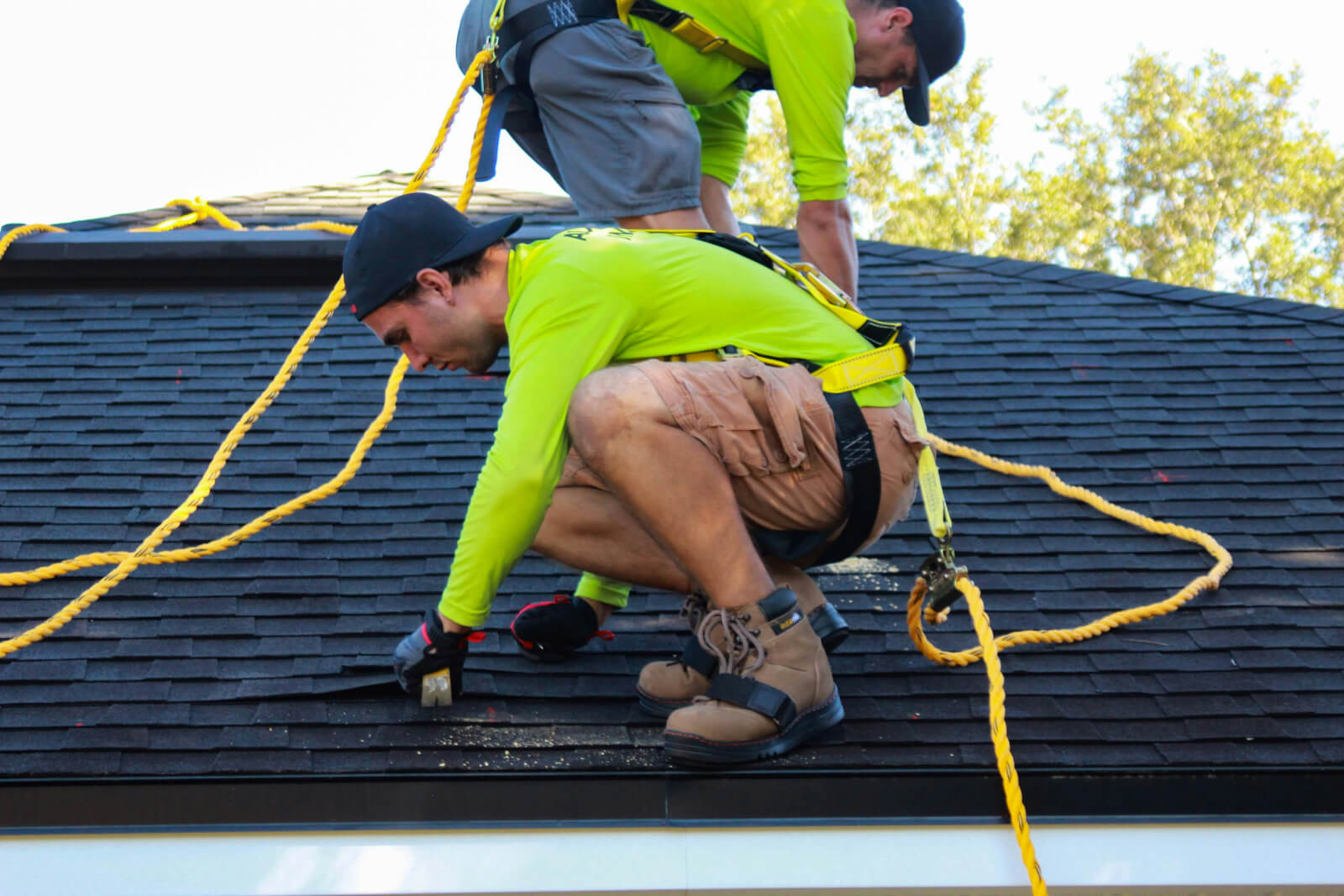 A roofing crew working on a residential asphalt shingle roof