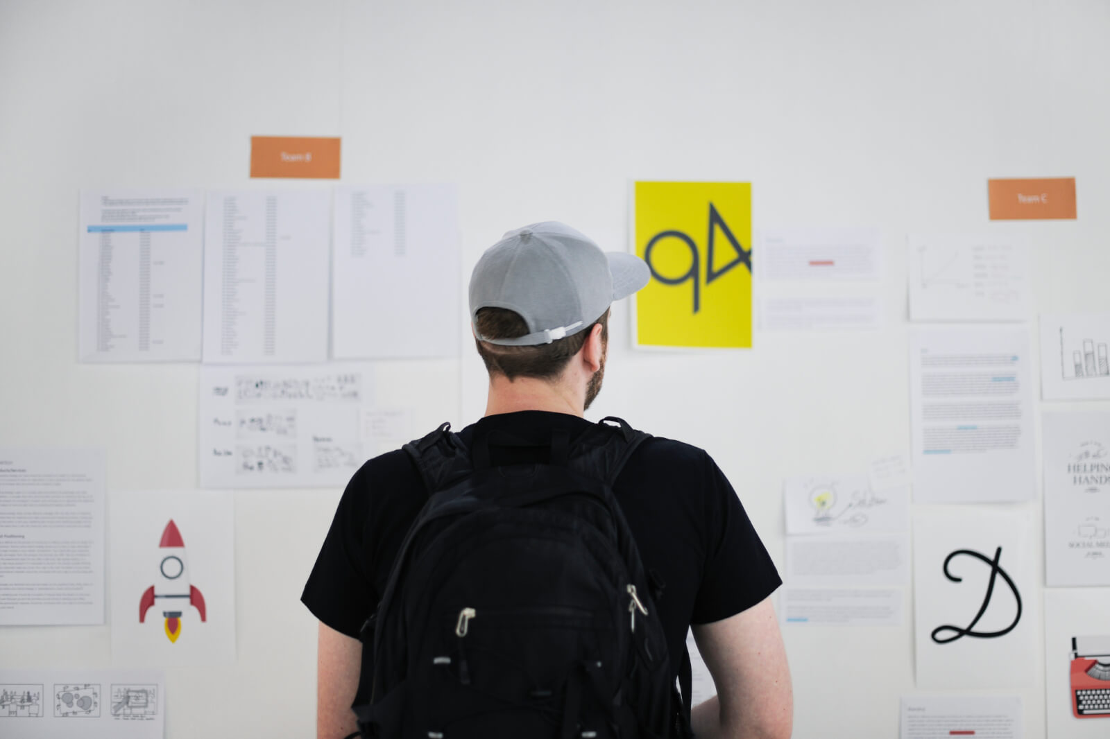 Someone studying a wall of printed research and strategy notes
