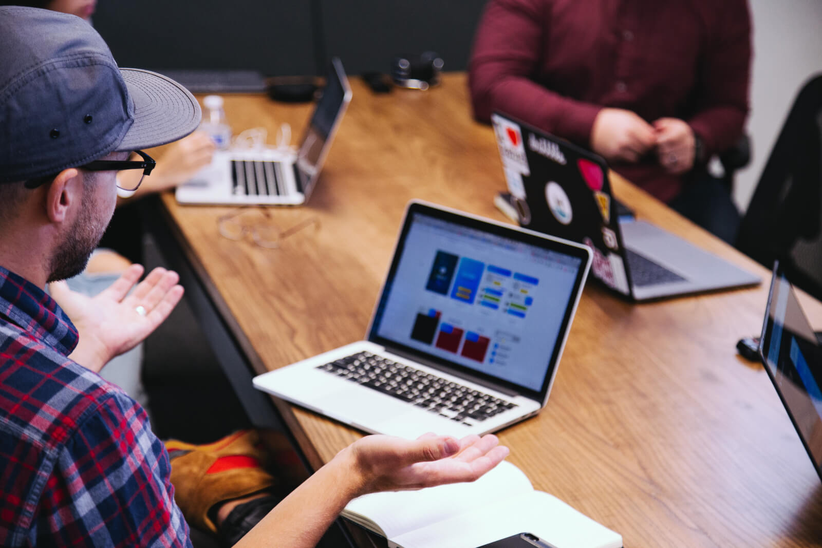 Laptops and dashboards open around a meeting table